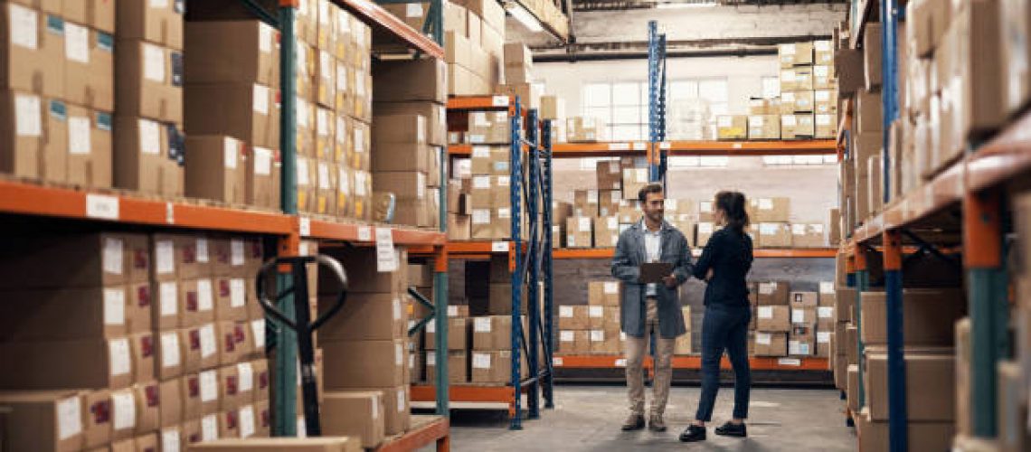 Shot of a young man and woman working together in a warehouse